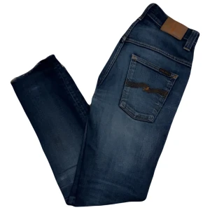 Nudie Jeans - Thin Finn Nudie Jeans, jeansen är avkortade från en 29/34 till en 29/32, defekter förekommer. Hål i båda fickorna och avkortade men för endast 199 kr är det dom billigaste man hittar, nypris 1600