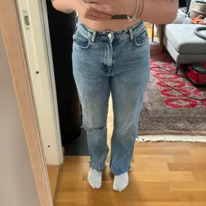 Hög midjade zara jeans med hål på ena benet. Bara använda några fåtal gånger så dem är i väldigt bra skick! Jag är 170 cm och dem passar bra i längden på mig!