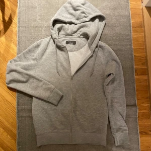 Grå zip hoodie  - Säljer denna stilrena zip hoodie då den blivit för liten. För mer frågor och bilder kom privat.