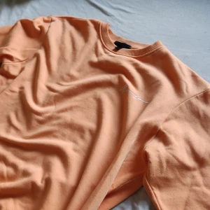 Mennace tröja - Fin peach färgad tröja från Mennace med tryck på ryggen, ganska bra skick. Står XS på lappen man hade nog funkat som S. Pris kan diskuteras