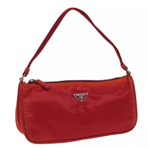 Prada väska - Ursprung: Italien   Material: nylon Färg: röd Tillbehör: inga   Viss missfärgning, men överlag bra skick. Kolla gärna bilderna! B 24cm x B 12cm x D 7cm