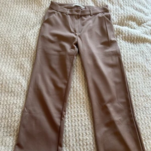 Kostymbyxor - Raka lågmidjade kostymbyxor som är stretchiga och justerbara vid midjan.  Så sköna och fina och endast använda en gång så de är i toppenskick🤎