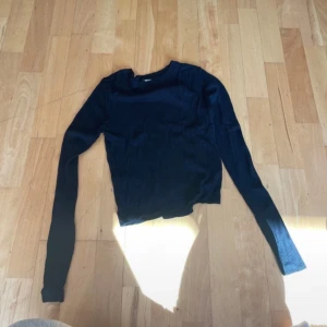 Svart långärmad tröja - Säljer en stilren svart långärmad tröja i normal passform. Perfekt för både vardag och fest. Tröjan är i bra skick och passar till det mesta i garderoben. Ett måste för höst- och vintergarderoben!