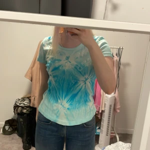 Blå tie-dye topp från Connect - Säljer en superfin blå tie-dye topp från Connect storlek 42/44 men passar mig bra som har s/m  ett coolt mönster med vita detaljer. Toppen är i mjukt material. Passar perfekt till jeans eller shorts!