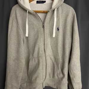 Grå hoodie från Polo Ralph Lauren. Storlek M. - Säljer för använder inte den längre. Bra skick. Inga hål ingenting.