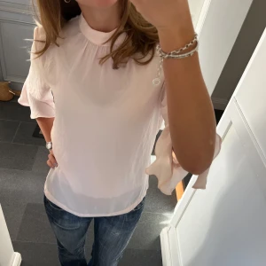 Rosa volangtopp - Rosa trekvartsärmad blus med volanger från H&M i storlek 36. Fint skick. Ganska genomskinlig så man kan behöva ett linne under. Använd gärna köp nu!