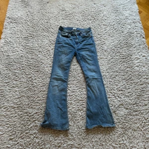 Blå bootcut jeans - Säljer ett par snygga blå bootcut jeans i välanvänt skick. De har en klassisk femficksdesign och är perfekta för en avslappnad stil. Passar bra till både vardag och fest. Perfekt för dig som gillar en retro look!