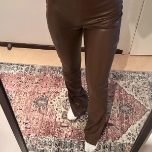 Läderbyxor - Bruna läderbyxor med slitningar längst ner. Passar S/XS. Helt oanvända. Från Nelly