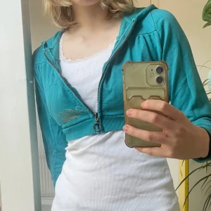 Y2K hoodie - En kort turkos y2k hoodie 🩵 Är så snygg med en najs topp och ett par lågmidjade jeans 😍 äkta 2000-tals feeling alltså 🌟