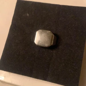 Silverfärgad ring med fyrkantig design - Snygg  ring i silverfärg med en cool fyrkantig design. Perfekt för att ge din outfit en modern touch. Ringen har en slät yta och är bekväm att bära. Passar både till vardags och festliga tillfällen.