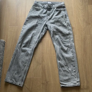 Grå jeans från Grunt stl 28 - Säljer ett par grå jeans från Grunt i storlek 28 då de inte används längre. De har en klassisk design med knapp och dragkedja framtill. Perfekta för en avslappnad stil och passar till de flesta tillfällen. De är i mycket bra skick och redo för en ny ägare! Kvitto finns! Skriv vid frågor😊
