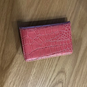 Rosa plånbok med krokodilmönster - En fin rosa plånbok/korthållare med krokodilmönster. Den har en stilren design och är perfekt för att hålla flera kort och kontanter organiserade!