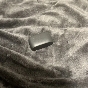 Grå Jabra hörlursfodral - Säljer ett grått Jabra hörlursfodral i bra skick. Perfekt för att skydda dina trådlösa hörlurar och hålla dem laddade. Fodralet är kompakt och lätt att bära med sig. Passar perfekt i fickan eller väskan.