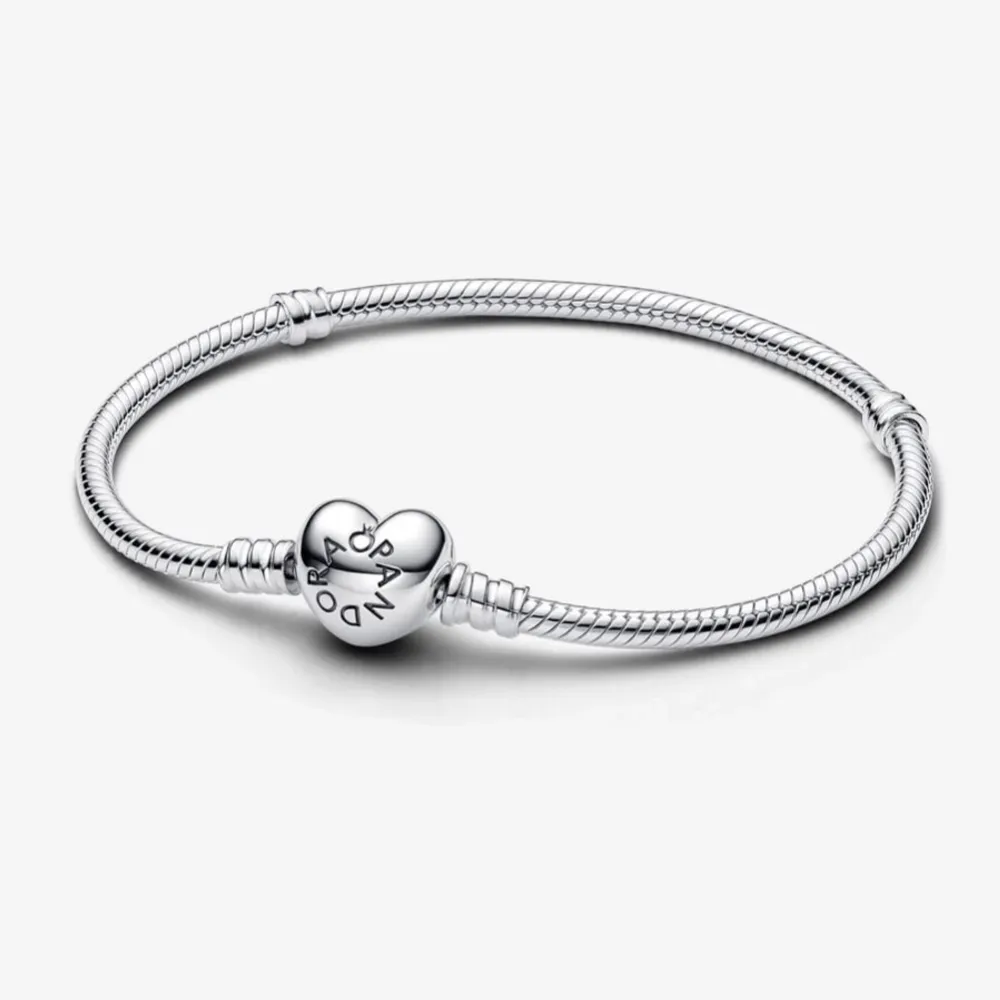 Snyggt och stilrent silverarmband från Pandora med ett hjärtformat lås. Perfekt för att bära till både vardag och fest. Armbandet har en elegant design och är lätt att matcha med andra smycken🥰säljer även charms som man kan lägga på! Skriv för storlek och mått. Accessoarer.