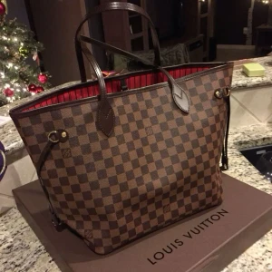 Tote bag Neverfull MM - Neverfull MM damier modellen i färgen röd. Rensar min garderob inför en flytt därför säljer jag arnas superfin och i mycket bra skick med inga defekter. Har inte kvitto då de va en present! 28 x 14 x 31 cm. Bara seriösa skriv.