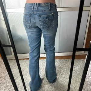 Lågmidjade bootcut jeans  - Så snygga och unika lågmidjade bootcut jeans, storlek 27 enligt lapp, något större i storleken enligt mig. Innerbenslängd: 83 midjemått:37. Knapphålet är lite uttöjt. Annars fint skick. Köp sker via köp nu, jag postar inom 24h. Kvar tills markerad såld 