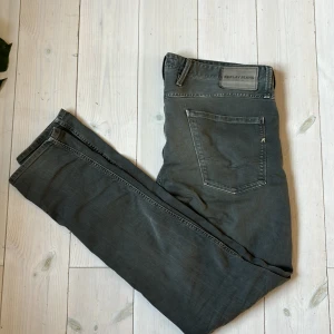 Replay Anbass jeans  - Schyssta jeans från märket Replay Modell:Anbass  Storlek: W33 L32 Färg:Grå Hör av er om ni har några frågor