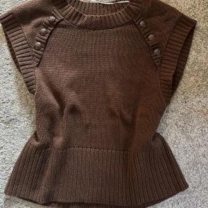 Stickad brun väst  - Väst från rabalder, perfekt till höst och vinter. Kan stylas med skjorta men även bara ha som den är. Köpt för ungefär 800kr. 