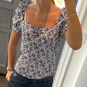 Blommig topp - Blommig topp från H&M i storlek M. Fint skick. Säljer även kjolen från Replay. Använd gärna köp nu!