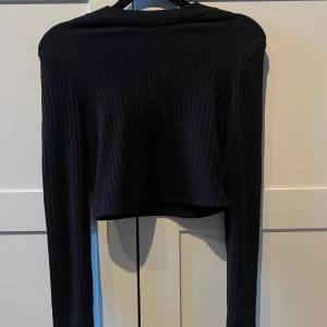 Svart ribbad croppad topp - Svart ribbad topp med långa ärmar, ny med prislapp kvar!