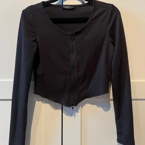 Svart ribbad croppad topp - Snygg svart topp, croppad och har en dragkedja framtill. Toppen har långa ärmar och en tight passform❤️‍🔥