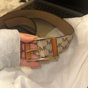 Äkta Michael Kors Bälte - helt oanvänd MK bälte. fick i present o eftersom ja nt använder bälten så har den bara legat hemma i en låda. 