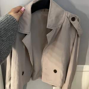 Tunn jacla - Säljer en beige, tunn jacka/kofta från shein i storlek S passar perfket till sommaren med en klänning mm. Jätte fina detaljer, samt knytningar på ärmarna och bak. En knapp är sönder där fram, men går säkert att köpa liknande o nåla fast! (Fler bilder