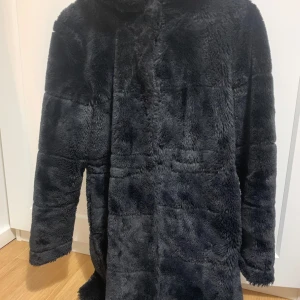 Svart pälsjacka - Plaggets skick är i mycket bra kondition och har dessutom jätte varm insida och utsida, perfekt för vinter vädret!