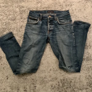 Blå jeans från Nudie Jeans - Säljer ett par blåa Nudie jeans. Jeansen är i 31/32 och har slim passform. Defekter vid fickan. 