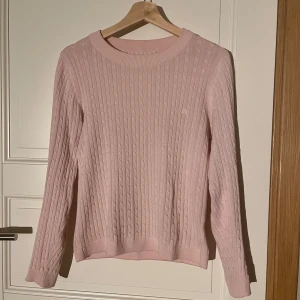 Rosa kabelstickad tröja - fint skick! lappen/etiketten är bortklippt, men sitter som en xs-s! okänt märke. liten logga vid vänstra bröstet. kontakta mig om du undrar nåt! 💗 