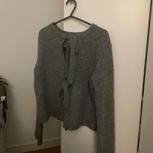 Grå stickad kofta från Object - Kofta med rosettknytning. Superfint skick, nästintill oanvänd. Använd fåtal gånger. 