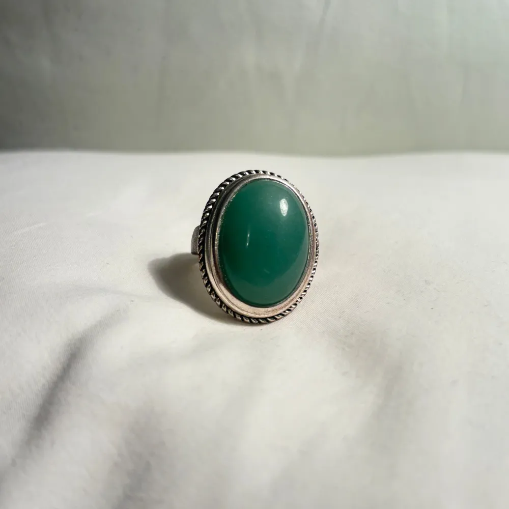 Maffig stor oval grön sten-ring i en detaljerad silverram. Vintage men i bra skick! . Perfekt för att ge en färgklick till din outfit.. Asusteet.