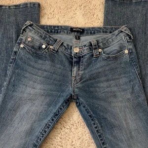 Blåa True Religion jeans - Säljer mina blåa true religion jeans som är i modellen ”ultra low rise joey flare sn”, använda ett fåtal gånger och är i mycket bra skick!                  Nypris 1400