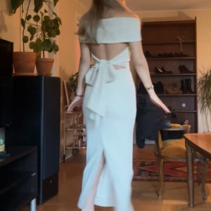 Beige offshoulder klänning - Beige klänning med offshoulder-design och knytning i ryggen. Bilderna är från video därav dålig kvalite kommer uppdatera annonsen med nya bättre bilder sen!