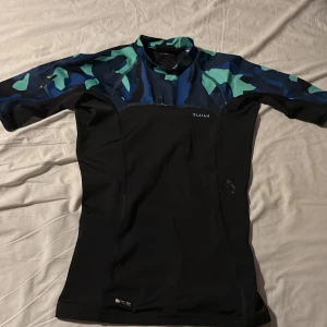 Svart och blå UV tröja från Olaian - Säljer en vattentät  UV tröja, håller upp till SPF 50 bra för barn runt 10 - 13 år. 