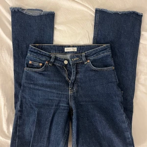 Mörkblå jeans från ginatricot  - Snygga mörkblå jeans med råa kanter och klassisk femficksdesign. Perfekta för en avslappnad stil. De har en knappgylf och bälteshällor för extra stilpoäng.