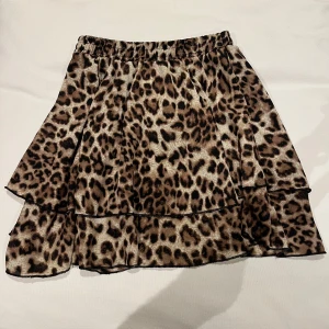 Leopardmönstrad kjol med volang från Raglady - Snygg leopardmönstrad kjol med volangdetaljer från Raglady. Kjolen har en elastisk midja för bekväm passform och är perfekt för att ge en trendig touch till din outfit. 🐆