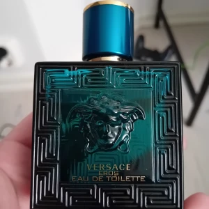 Versace Eros Eau de Toilette 50ml - Säljer en flaska Versace Eros Eau de Toilette, 50 ml. Flaskan har en djup turkos färg med ett elegant mönster och det ikoniska Medusa-huvudet. Korken är blå med gulddetaljer. Perfekt för den som vill ha en fräsch och maskulin doft.