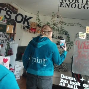 Blå velour hoodie från Juicy Couture - Säljer en snygg blå velour hoodie från Juicy Couture med dragkedja och huva. Den har texten 'Juicy' i glittriga stenar på ryggen. Perfekt för en avslappnad stil. Den är i XXL men sitter som en M på mig som igentligen har L i koftor. Alla stenar är kvar och använt max 2 gånger. Lappen på insidan är avklippt då den skavde.