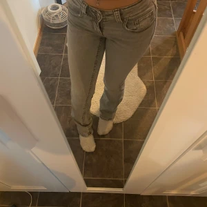 Grå jeans från Gina Tricot - Snygga grå jeans från Gina Tricot med en tight passform. De har klassiska femficksdetaljer och en knappgylf. Perfekta för en stilren look.