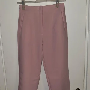 Rosa kostymbyxor - Snygga rosa kostymbyxor med hög midja och raka ben. Byxorna har diskreta fickor framtill och en dragkedja i sidan för en smidig passform. Perfekta för en stilren look. Från zara endast testade🩷