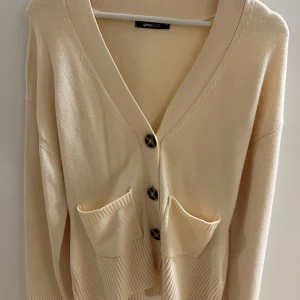 Figursydd kofta från Gina Tricot - Den populära och slutsålda figursydda koftan från Gina tricot. Creme färgad. Vida ärmar. Knappar framtill och även små fickor. Jätte fin kvalité. Endast använd 1 gång 🤍