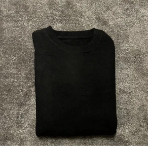Svart tröja - Snygg och stilren svart tröja med rund hals. Perfekt för en minimalistisk look. Köpte den för Två månader sedan men säljer den nu då den varit för liten för mig. Liten i storlek så passar mer i XS.