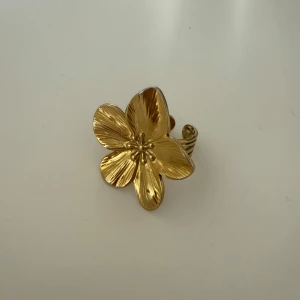 Guldfärgad blomring  - Elegant guldfärgad ring formad som en blomma med detaljerade kronblad. Perfekt för att ge en touch av naturinspirerad stil till din look. Justerbar storlek för att passa de flesta fingrar. Säljer då den inte kommer till användning 💓! Priset kan diskuteras vid snabba köp! 💓