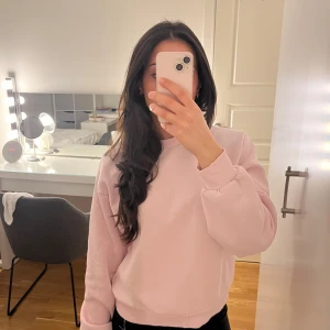 Ljusrosa sweatshirt från ginatricot  - Säljer en ljusrosa sweatshirt med rund hals och långa ärmar. Tröjan har ribbade muddar vid ärmslut och nederkant, vilket ger en bekväm passform. Perfekt för en avslappnad stil. Har samå svarta fläckar på ärmen. Hör av dig vid intresse! 💖