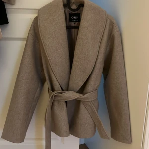 Beige kappa från ONLY - Beige kappa från ONLY med knytbälte i midjan. Köpte för 700 kr och aldrig använt! ❤️
