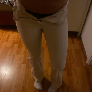 Beige 70-talsinspirerade byxor - Snygga beige byxor med hög midja och utsvängda ben i 70-talsstil. Säljer då de tyvärr är för små för mig. ! DE ÄR HÖGMIDJADE MEN VIKT NER DOM! Jag är 177 för referens så de är ganska långa🫶 köpt på nk för 1300kr. 