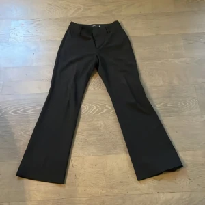 Svarta lågmidjade bootcut kostymbyxor - Snygga svarta lågmidjade bootcut kostymbyxor från Solero i en mix av polyester, ull och elastan. Byxorna har en klassisk design. Perfekta för en stilren look. Ingen bild på då dem ej passar❤️