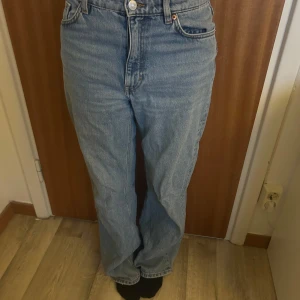 Blå jeans från Monki - Säljer ett par klassiska blå jeans från Monki. De har en hög midja och en straight passform. Perfekta för en avslappnad stil. De är köpta för ungefär 3 år sedan och är lite slitna vid sömnen längst ner, men annars är de i bra skick! 