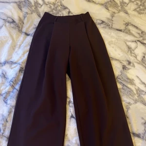Bruna kostymbyxor - Luftiga byxor med hög midja. Köpt på Nelly. Stretchiga runt midjan så passar xs-m.